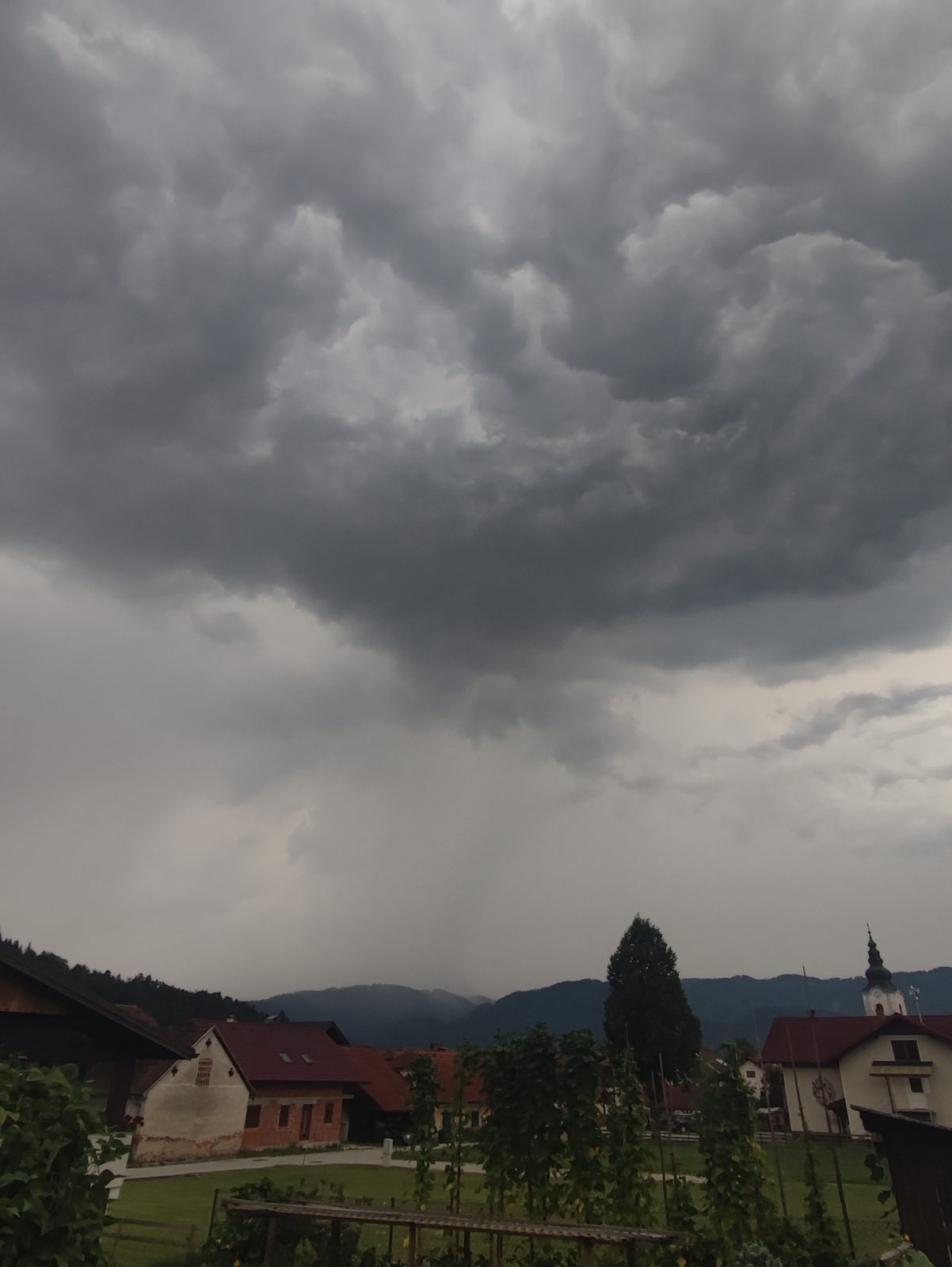 Nevihtni oblaki nad vaško cerkvijo v Zgornji Savinjski dolini